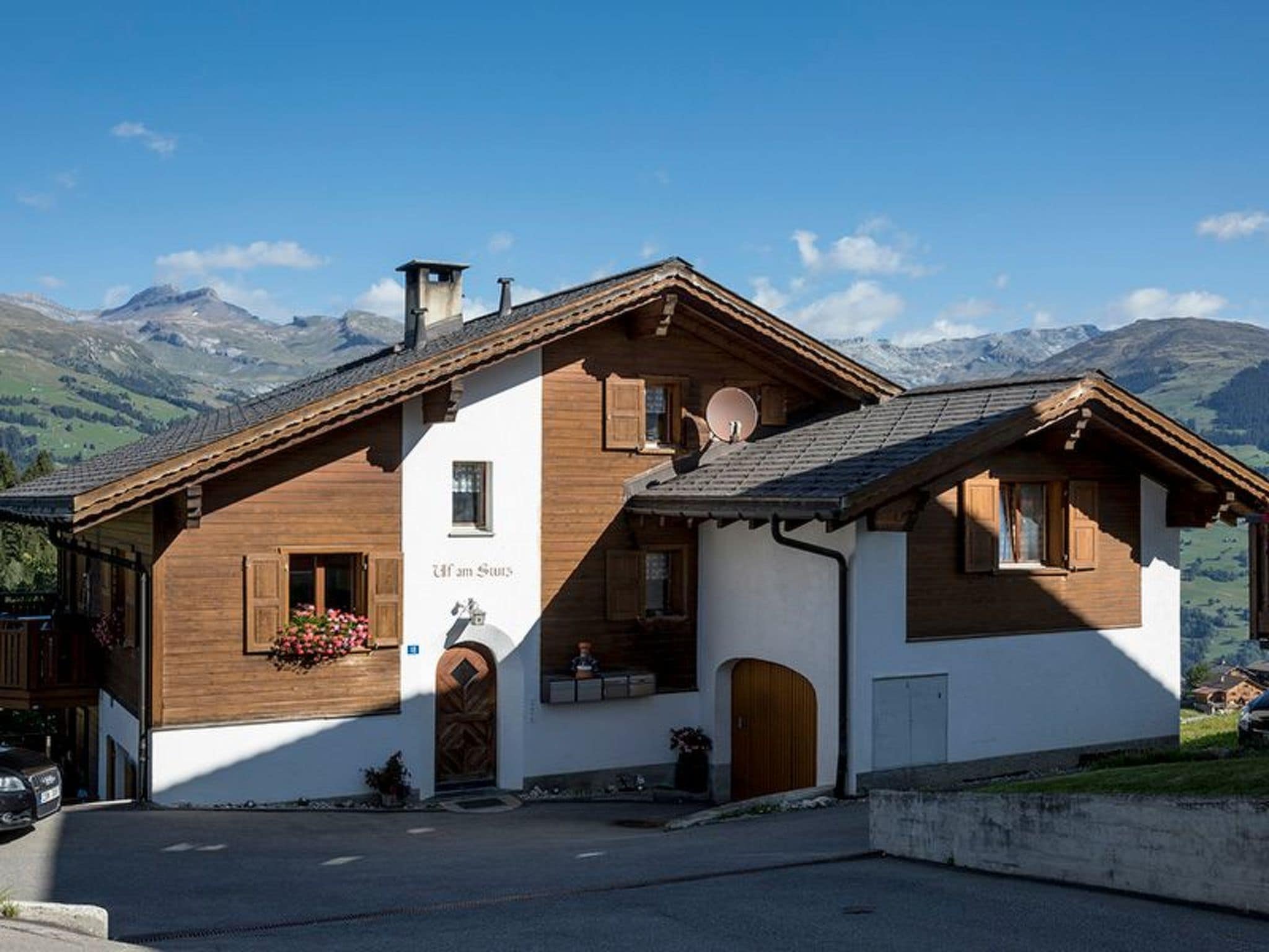 Una cabaña tradicional con fachada de madera, techo inclinado y un letrero que dice 'Uff am Stein'.