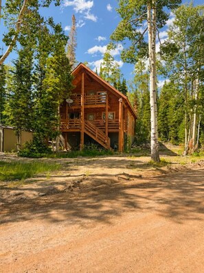 A wooden cabin with a porch and a staircase leading to a deck. - Mountain View Hideaway (Brian Head)
