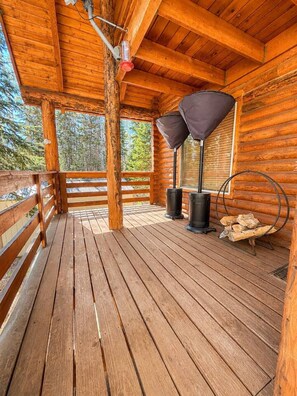 A wooden deck with a covered area, a fireplace, and a log storage. - Mountain View Hideaway (Brian Head)