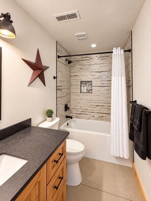 Un baño con ducha, inodoro y lavamanos.