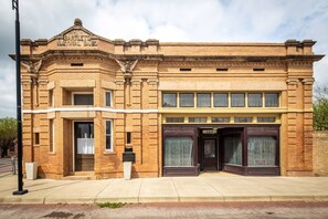 A historic building with a prominent entrance, a plaque, and a sign indicating a business.
