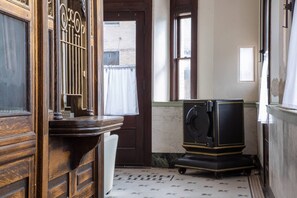 A room with a wooden door, a small table, and a vintage television set.