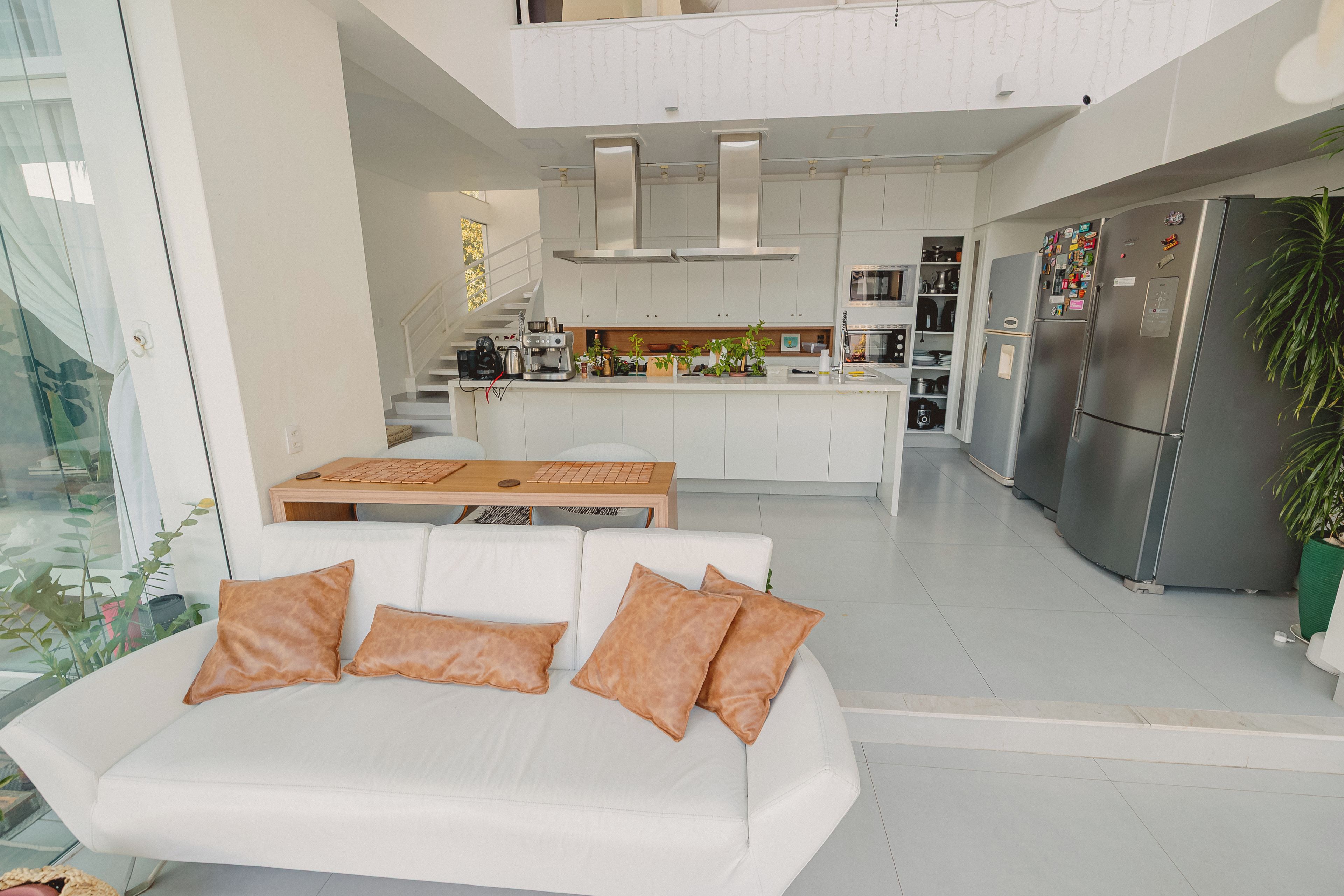 Una cocina moderna con gabinetes blancos, electrodomésticos de acero inoxidable y una isla central.