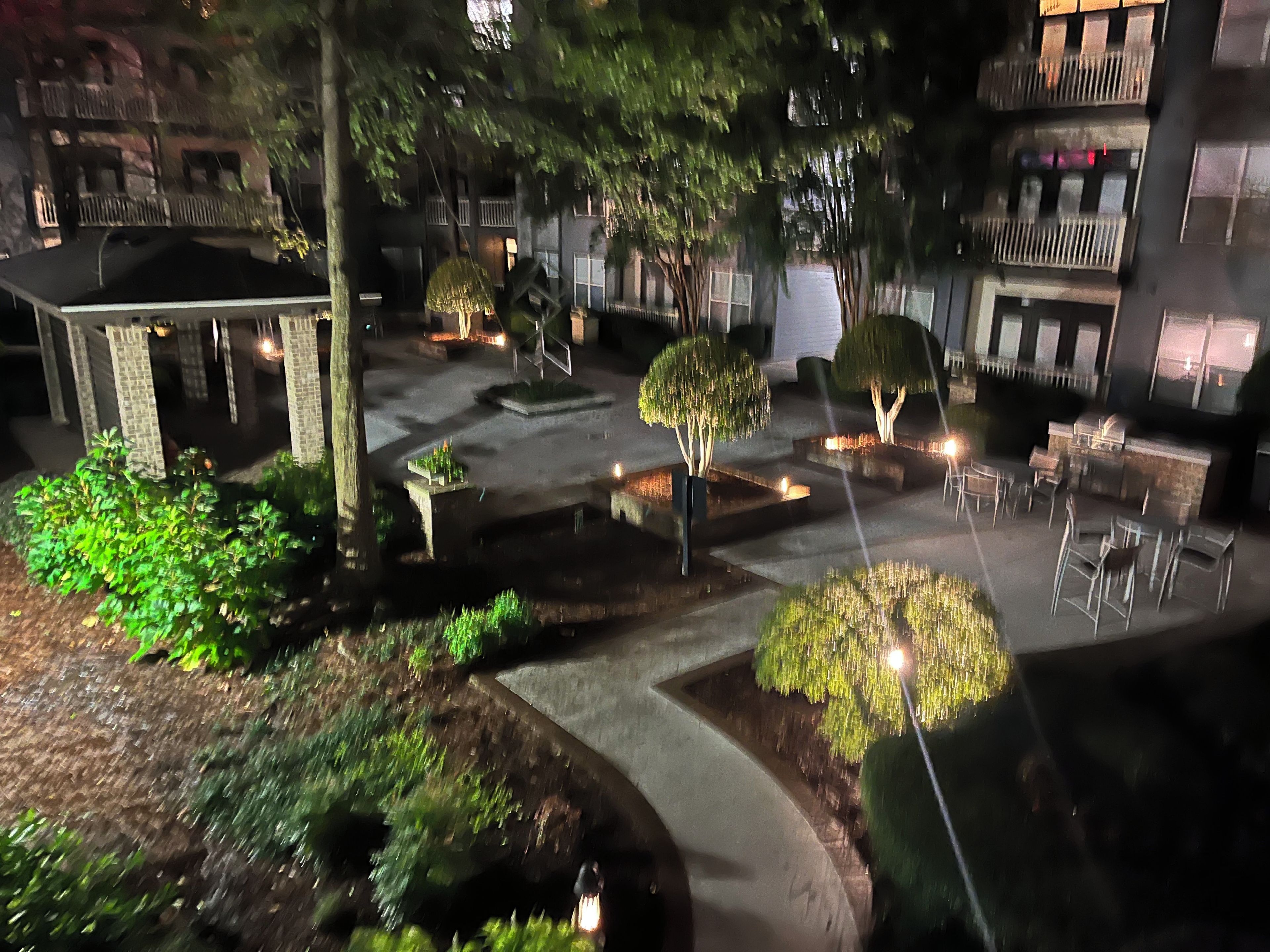 An outdoor courtyard with a gazebo, seating area, and a pool.