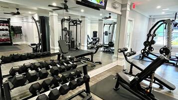 A gym with various exercise equipment, including dumbbells and weight machines.
