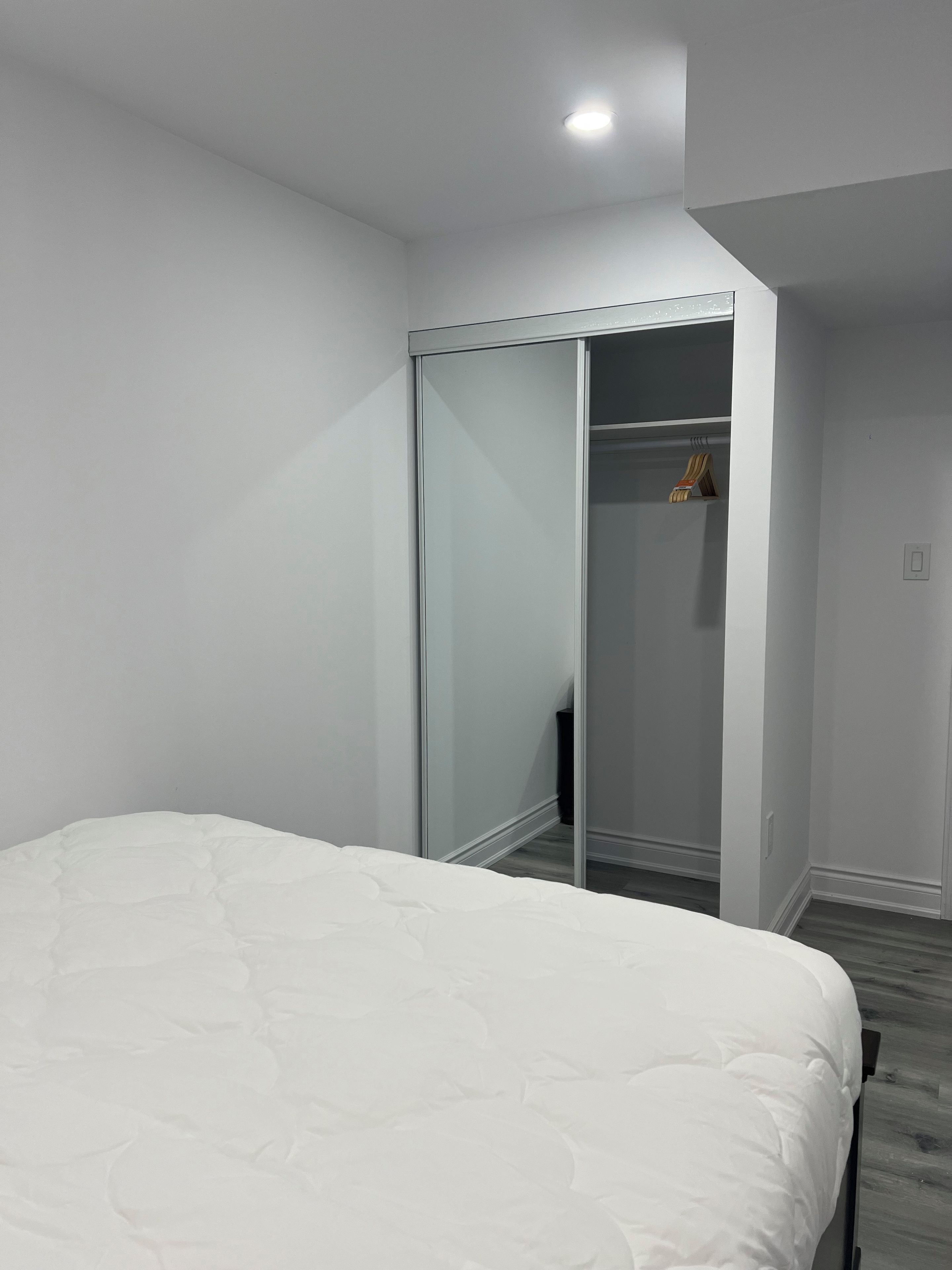A bedroom with a bed, a wardrobe, and a mirror.