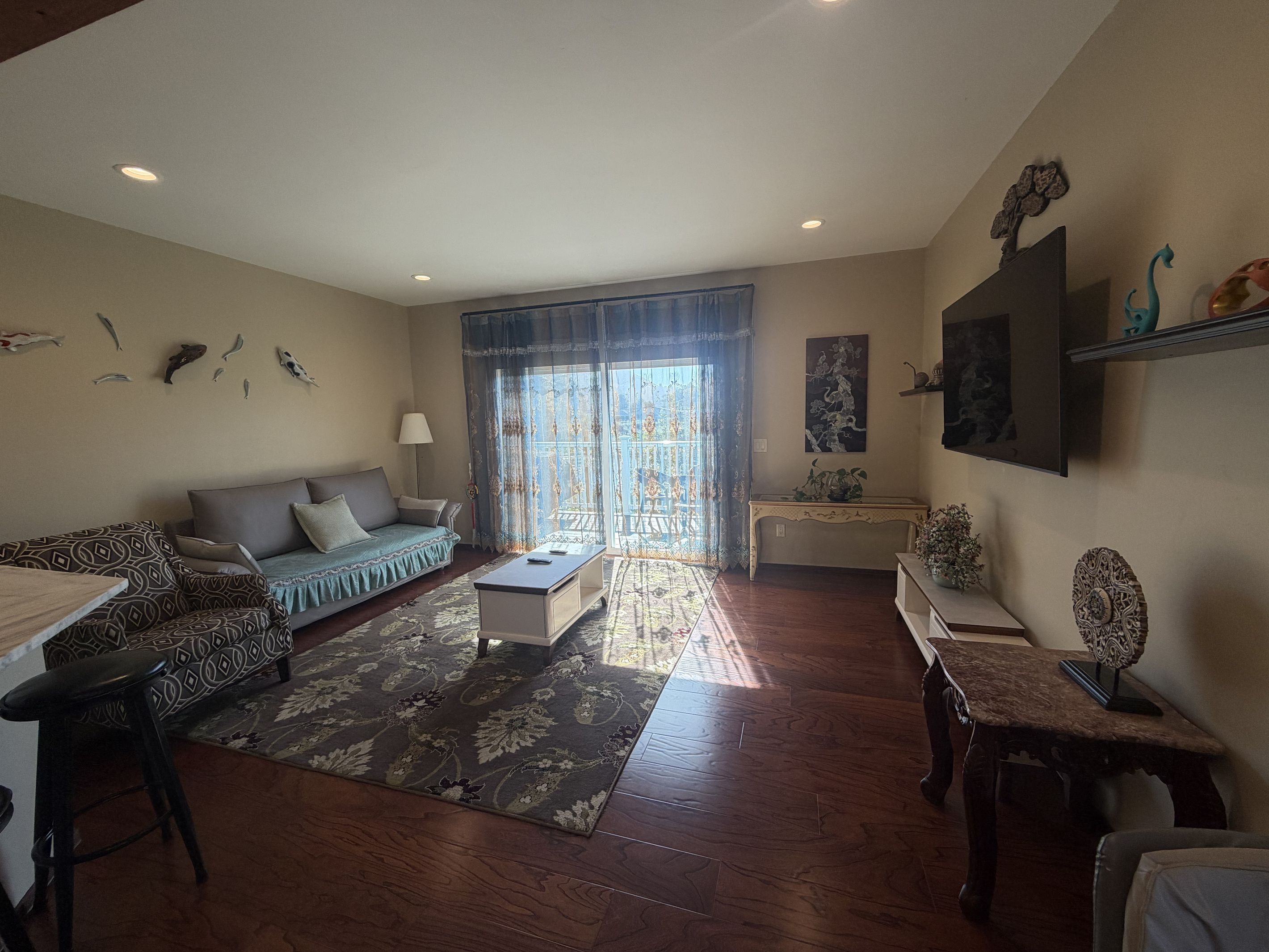 A living room with a sofa, coffee table, and patterned rug.
