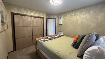 A bedroom with a bed, a wardrobe, and a ceiling light.