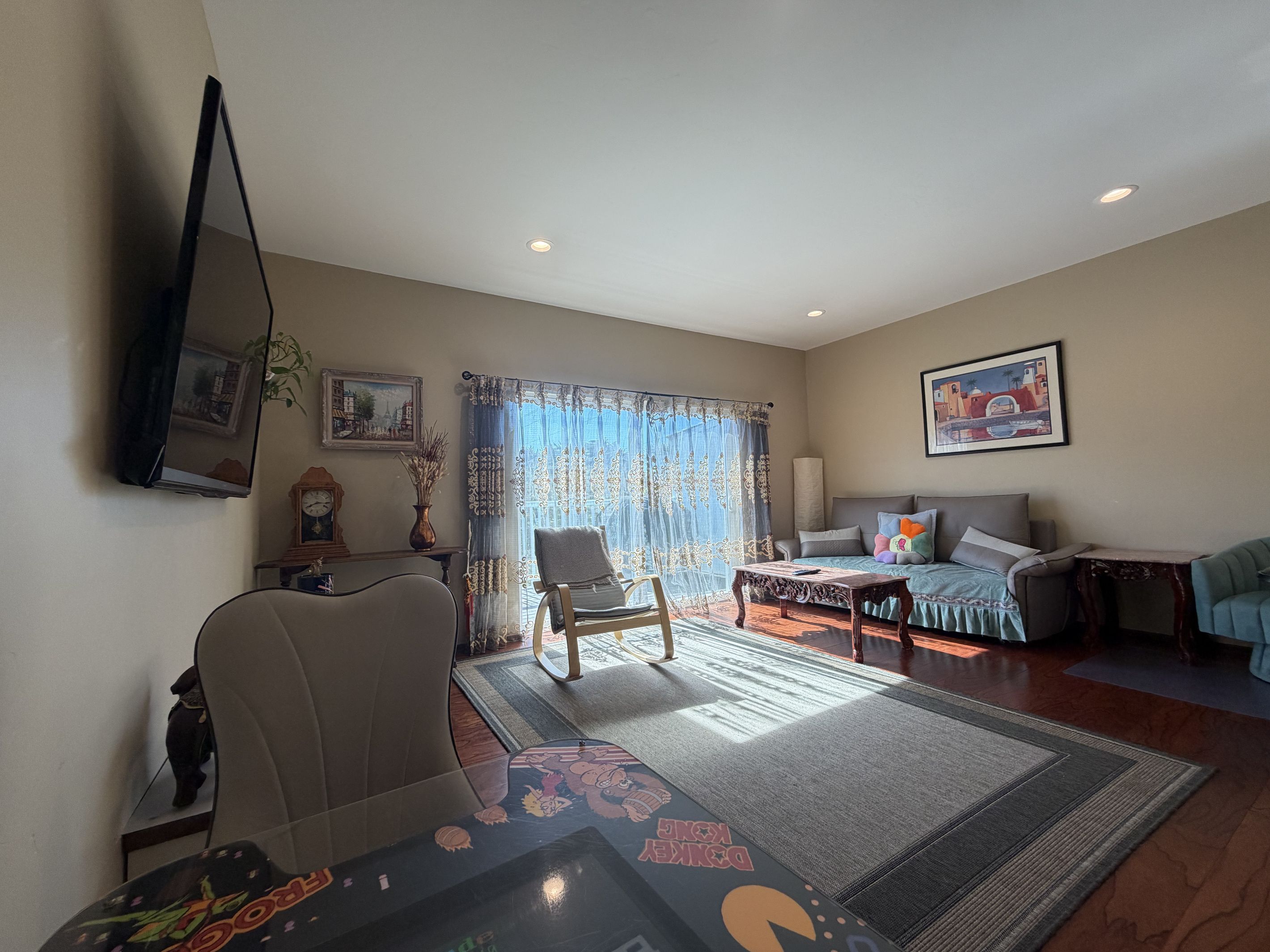 A living room with a sofa, armchairs, a coffee table, and a television.