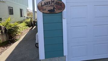 A wooden sign with the text 'Lakesmarie Lodge' and the number '32' on a teal building.