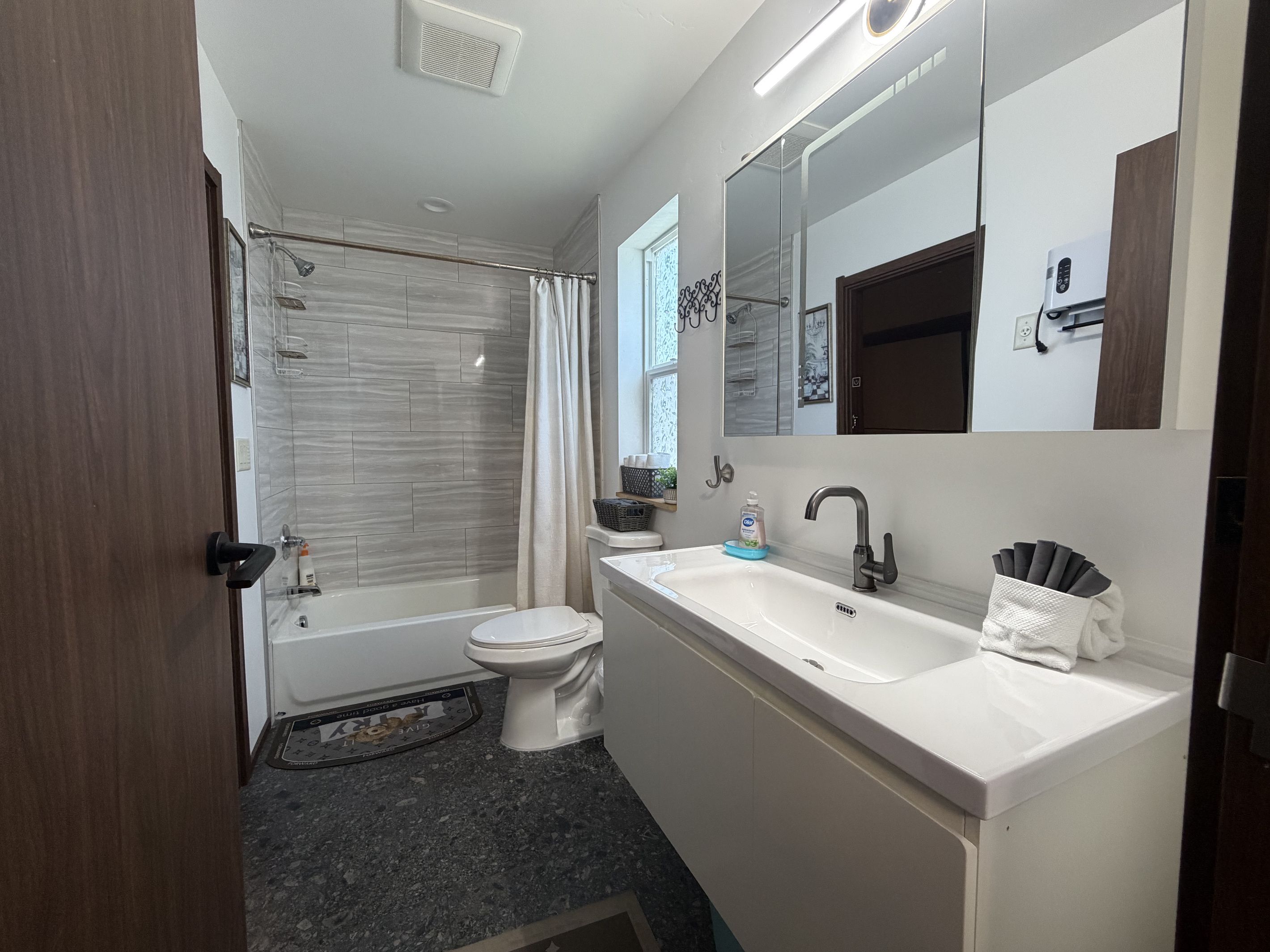 A modern bathroom with a bathtub, toilet, and sink.