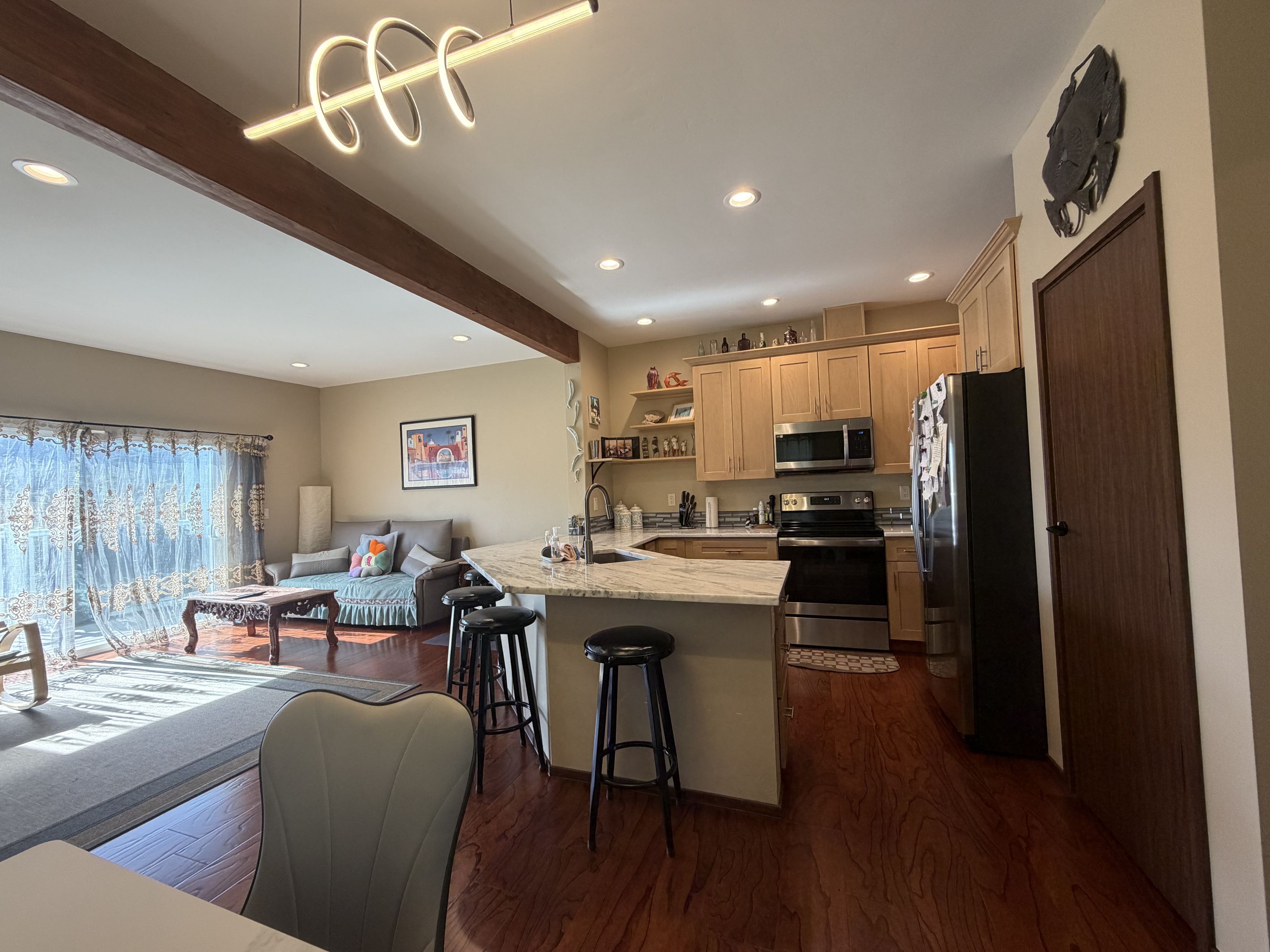 A modern kitchen with a central island, stainless steel appliances, and wooden cabinetry.