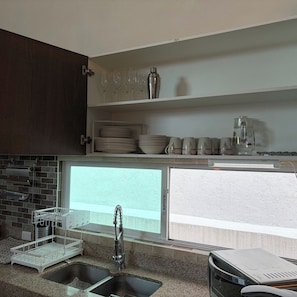 A modern kitchen with a granite countertop, stainless steel sink, and a window above the sink. - New Listing (Juriquilla)