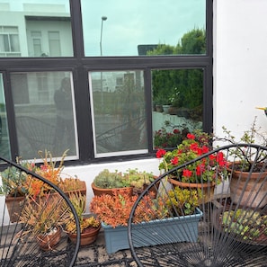 Un balcón con plantas en macetas y vista a la calle.