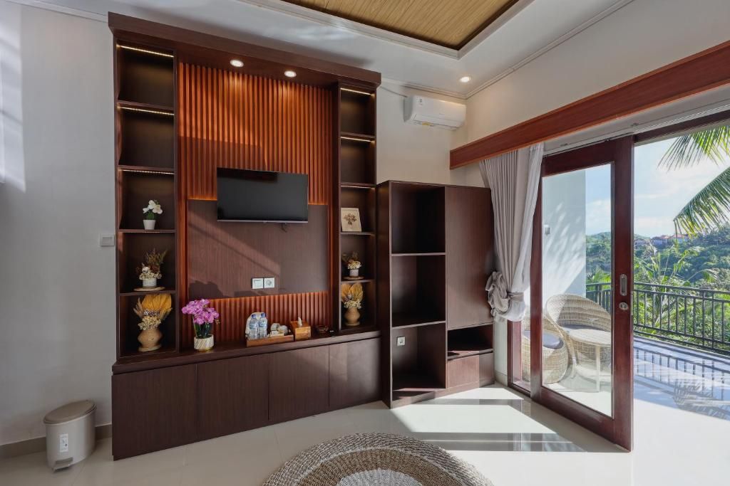 A modern living room with a built-in entertainment unit, a flat-screen TV, and a balcony with outdoor furniture.