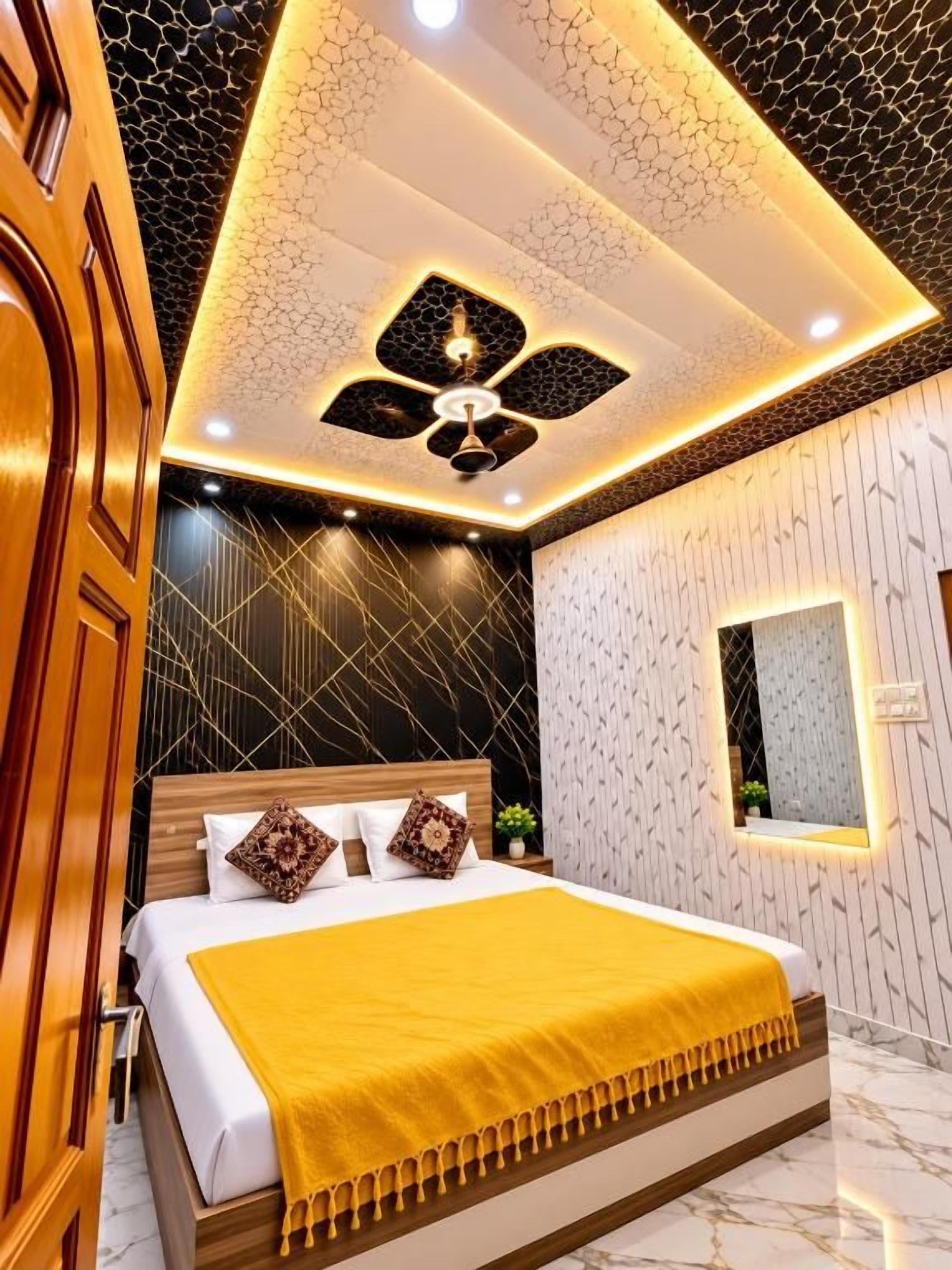 A modern bedroom with a bed, a ceiling fan, and a wall-mounted mirror.
