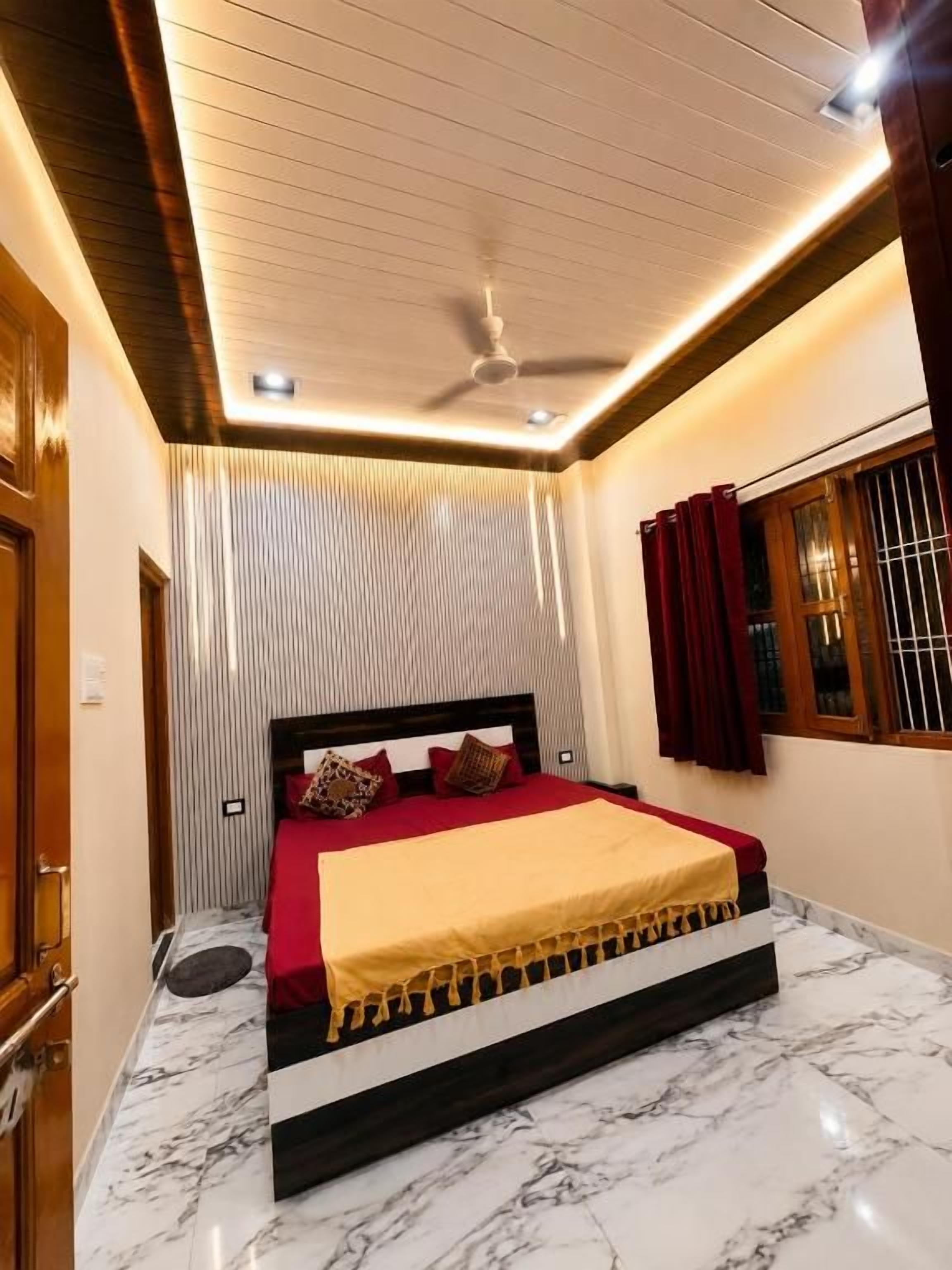 A bedroom with a bed, a ceiling fan, and a window with curtains.