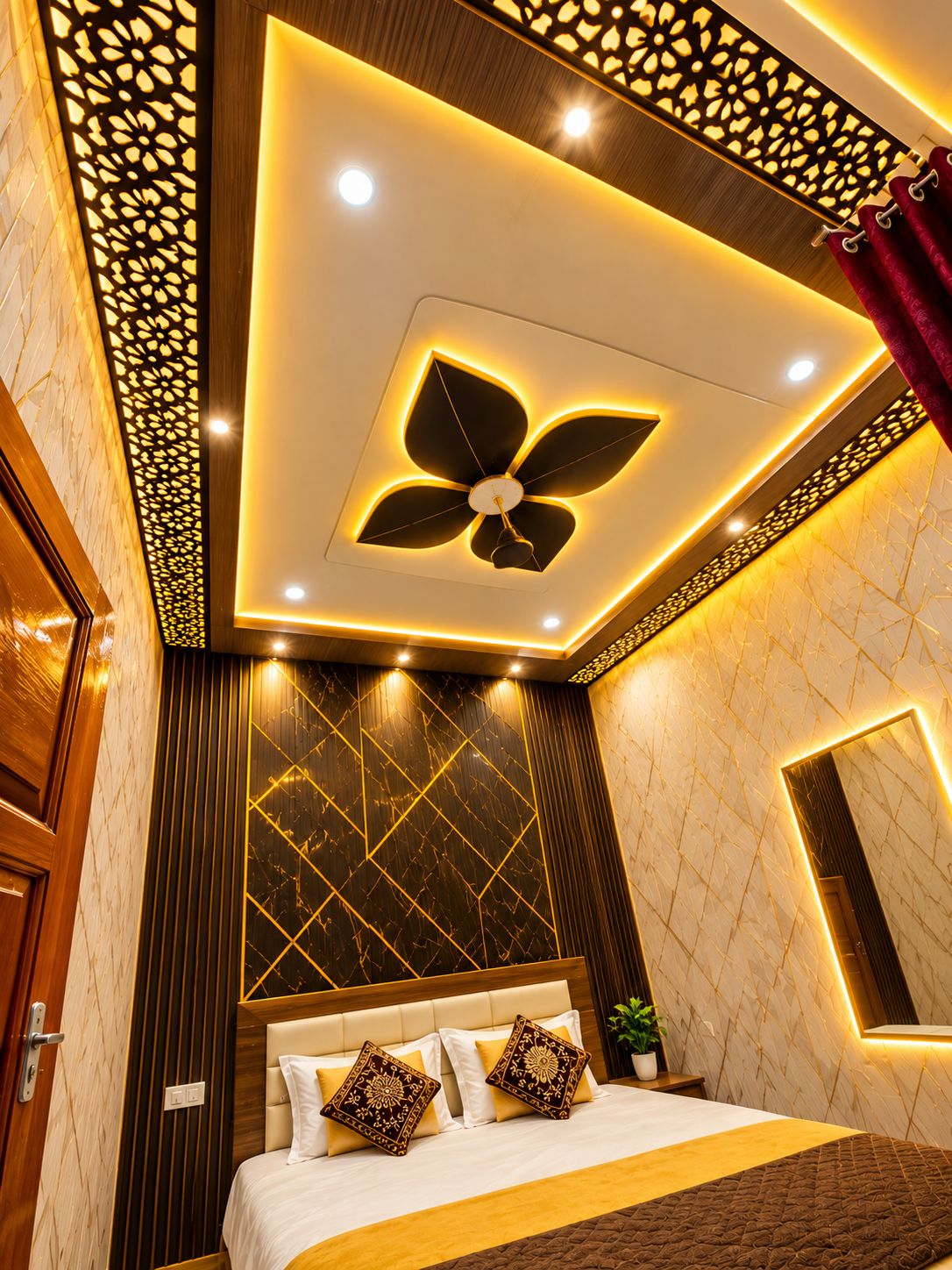 A hotel room with a modern ceiling design, a bed with decorative pillows, and a wall-mounted mirror.