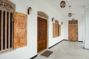 A hallway with wooden doors and a white wall. - White on White (Hikkaduwa)