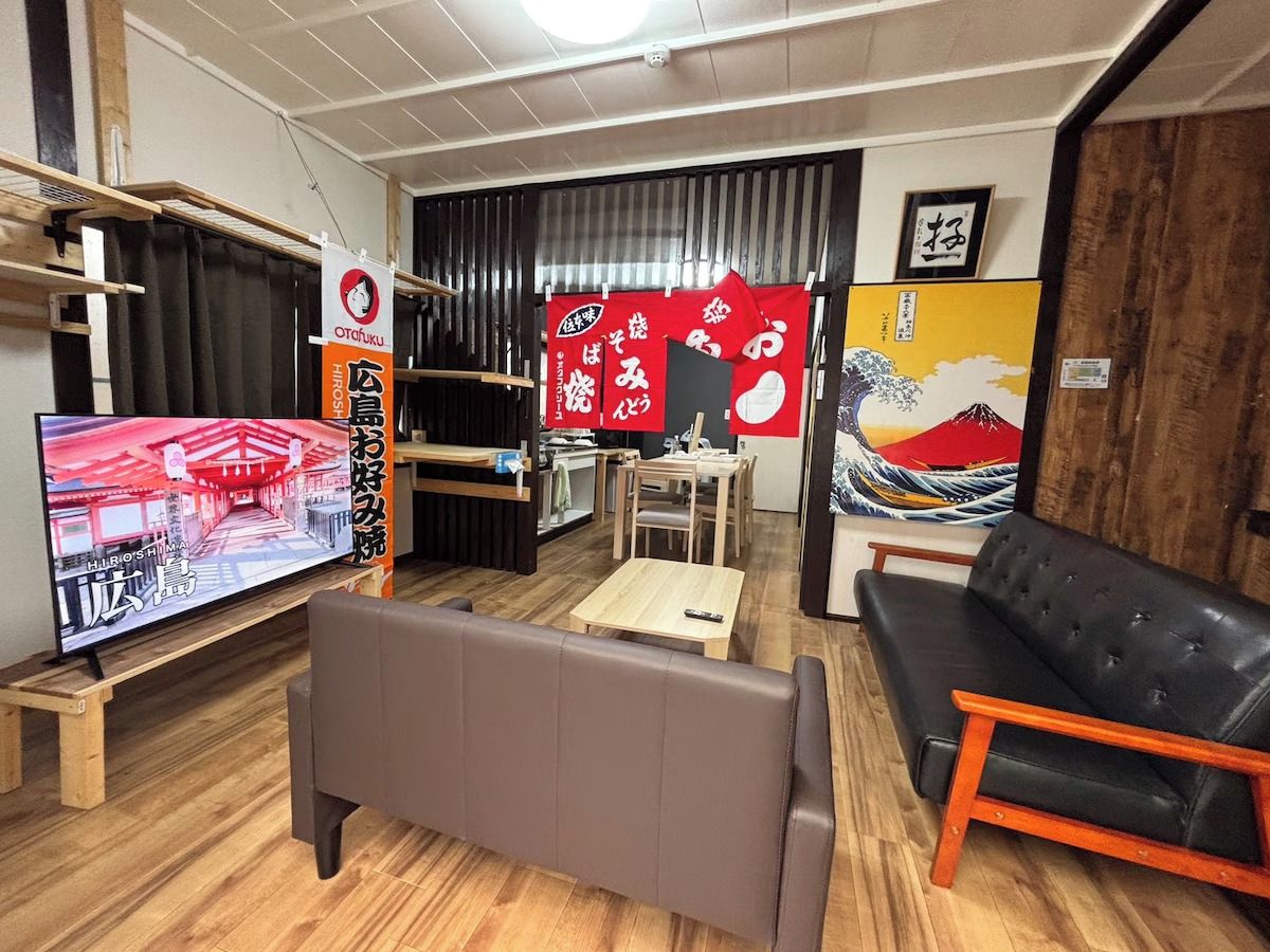 A living room with a television, sofa, and a dining area.