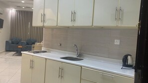A modern kitchen with a double sink, white cabinets, and a kettle on the countertop. - AlDurra AlRaqia (Medina)