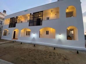 A two-story building with multiple arched windows and a flat roof. - The Silver leaf  (Budhanilkanth)