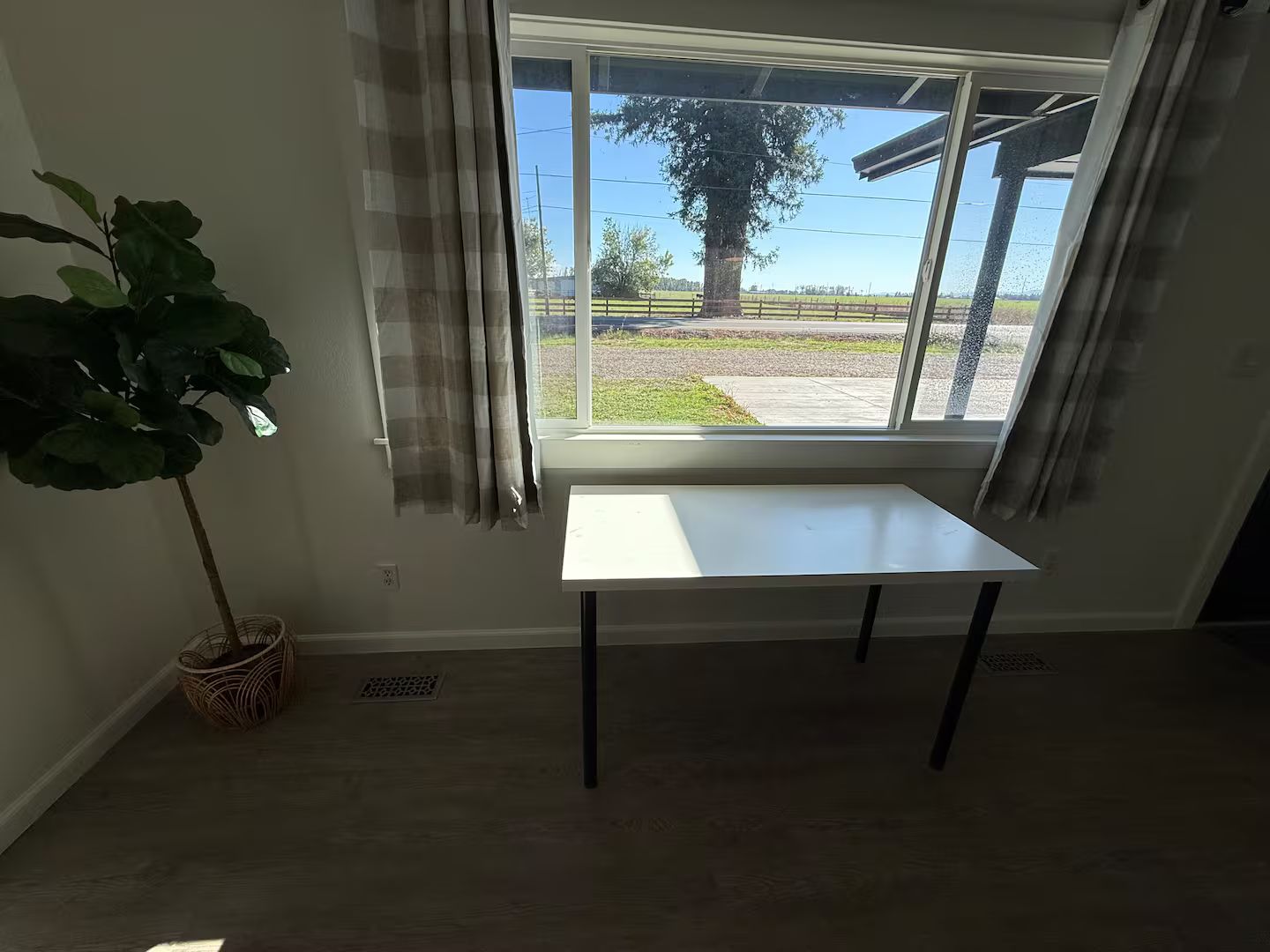 A room with a window, a table, and a potted plant.
