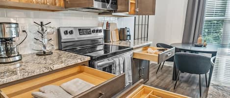 A modern kitchen with a built-in oven, microwave, and coffee maker.