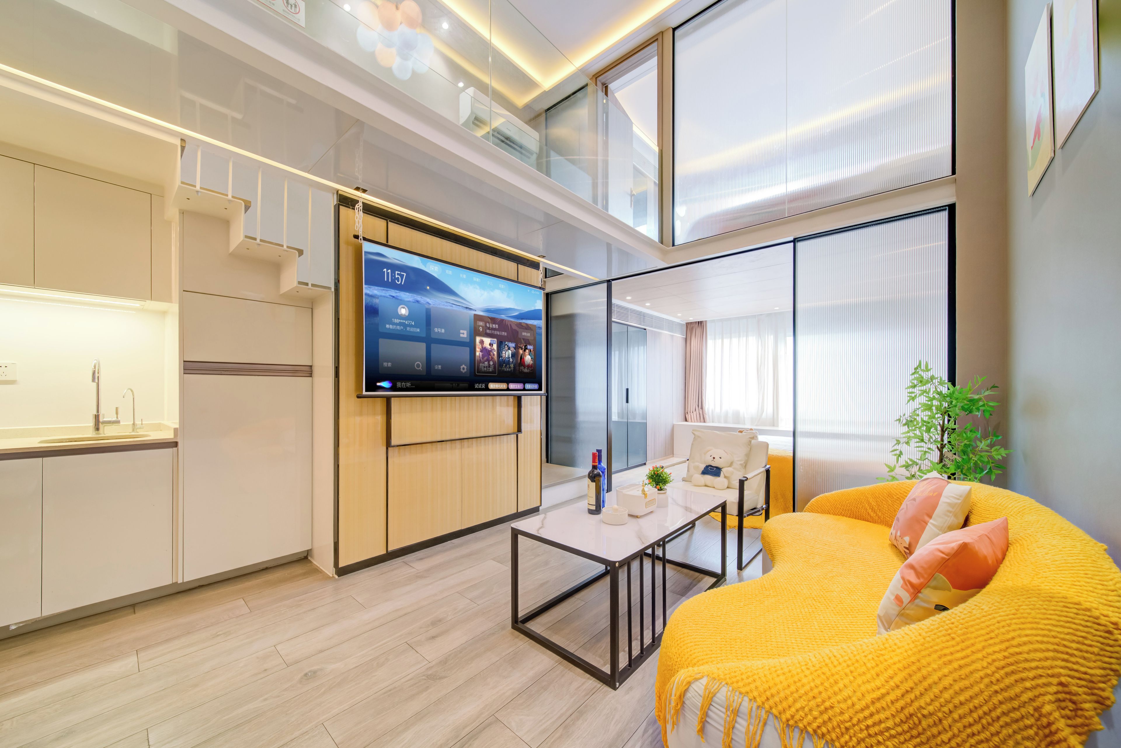 Un espacio habitable moderno con cocina, comedor y sofá con una manta amarilla.