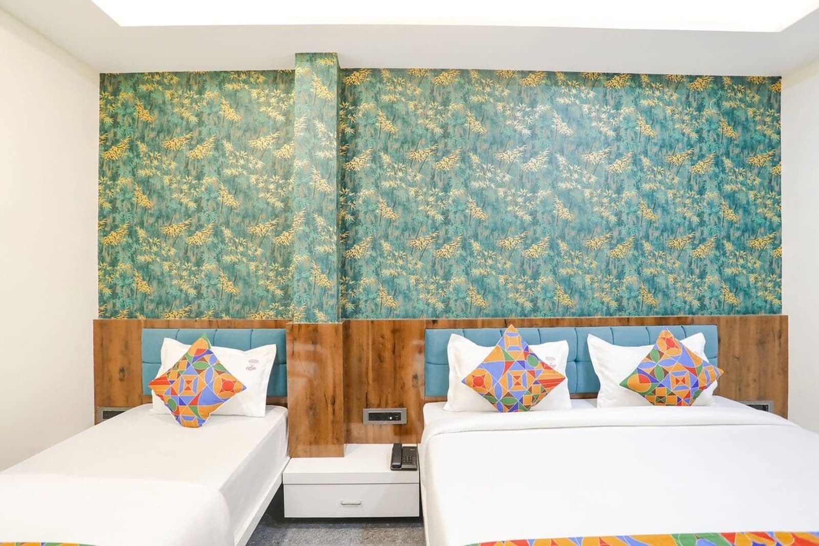 Une chambre d’hôtel avec deux lits, des têtes de lit en bois et une grande fenêtre.