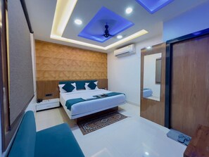 A modern bedroom with a bed, bedside tables, a mirror, and a ceiling light fixture. - Hotel Diamond Palace, Bhopal (Bhopal)