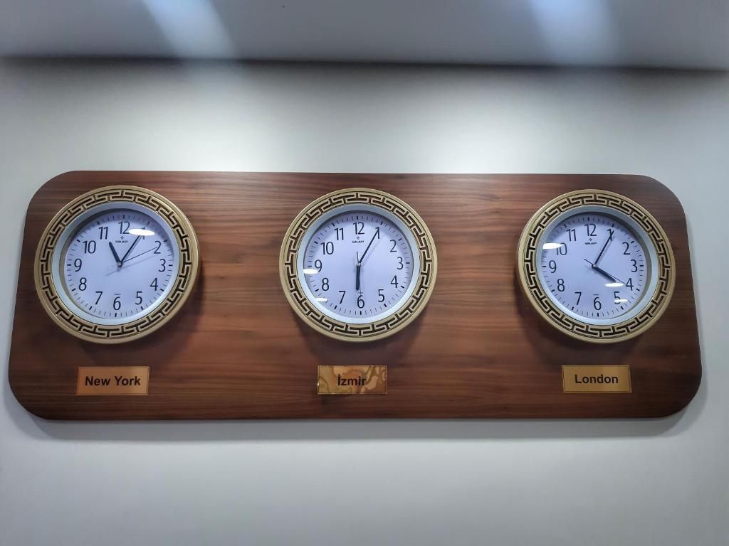 Drie wandklokken met verschillende tijdzones: New York, Izmir en Londen.