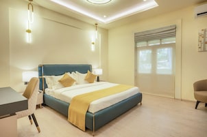 Ein modernes Schlafzimmer mit einem großen Bett, Nachttischen, einem Schreibtisch und einem Stuhl.