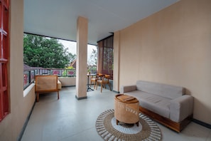 A balcony with a sofa, chairs, a table, and a decorative basket. - Dewangga MUA Ubud (gianyar)