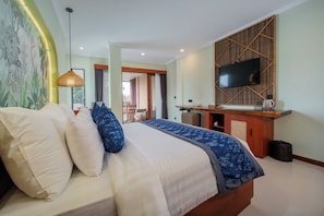Una habitación de hotel con cama, escritorio, televisión y vistas al exterior.