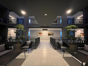 Um hall espaçoso com área de estar central, plantas em vasos e design moderno.