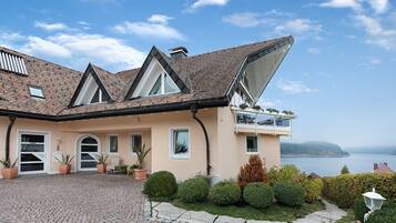 Une maison avec un toit en pente, un balcon et une vue sur la mer.