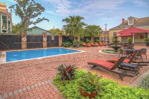 A swimming pool with lounge chairs and a patio area. - New Orleans | Streetcar Ride | Pool & Hot Tub (New Orleans)