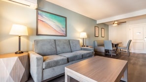 A modern living room with a grey sofa, a wooden coffee table, and a dining area with a table and chairs. - Anaheim | Disneyland Weekend Stay | Pool & Hot Tub (Anaheim)