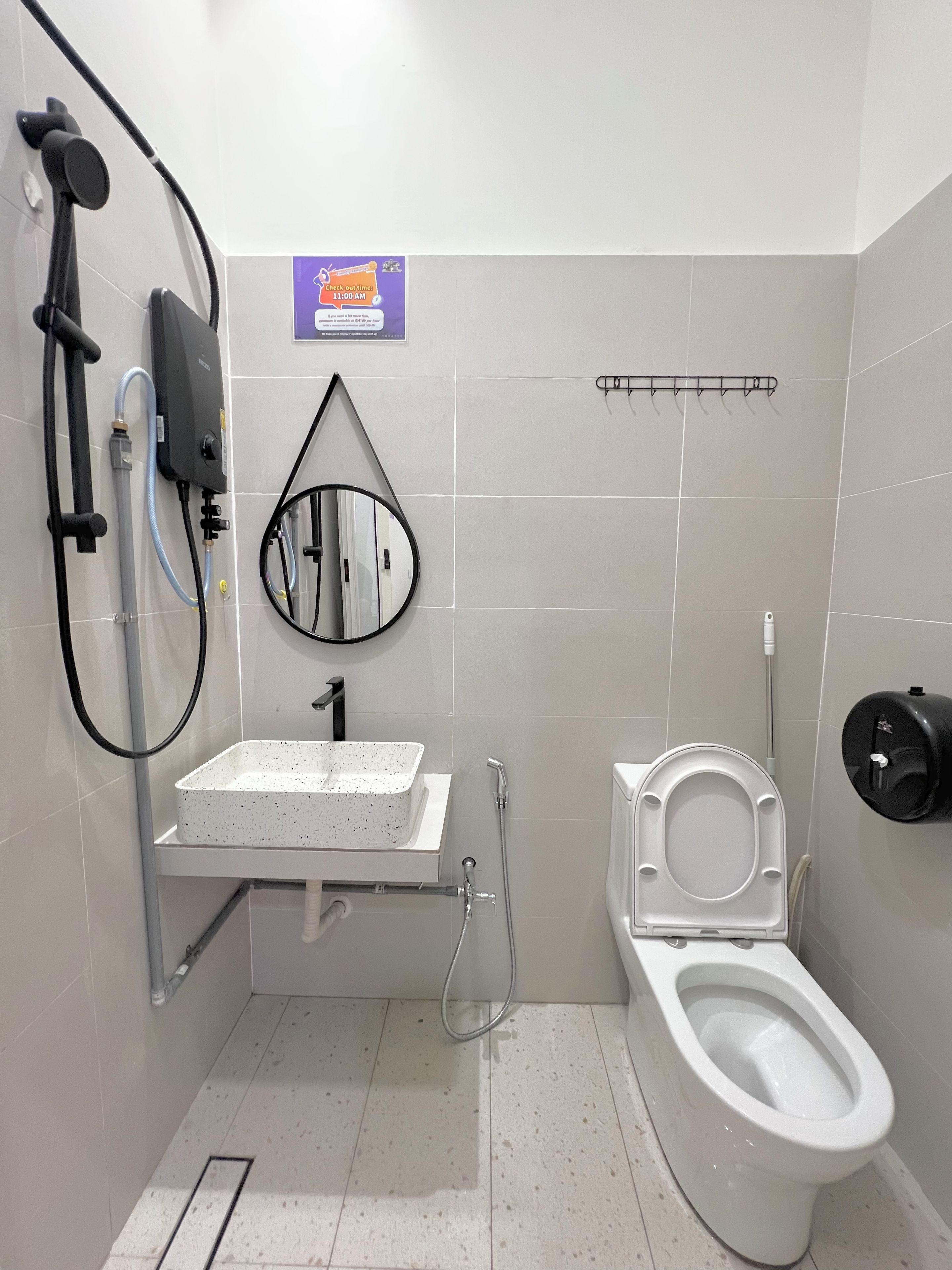 A bathroom with a toilet, a sink, a shower, and a mirror.