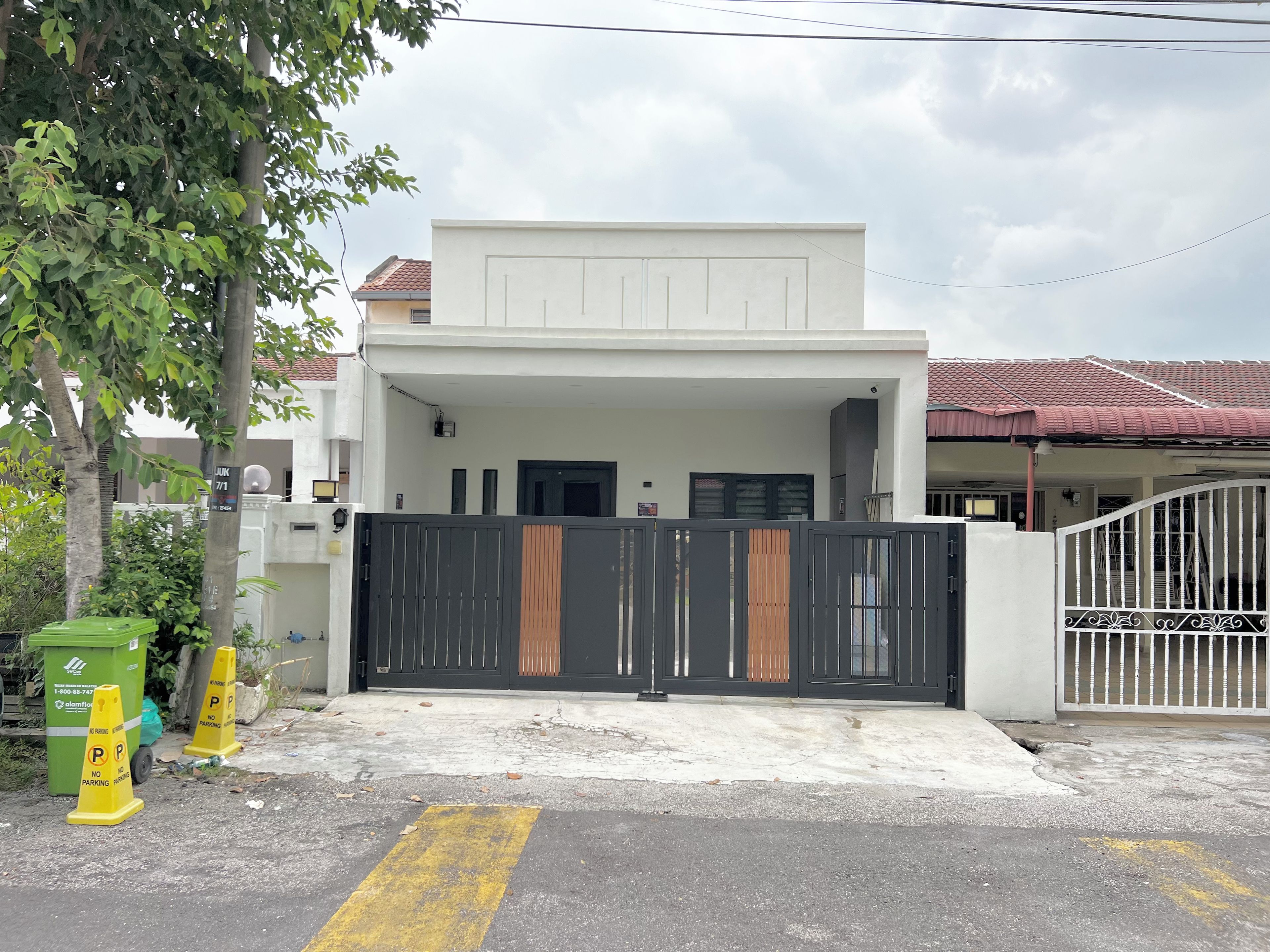 A gated residential property with a covered entrance and a visible garage door.