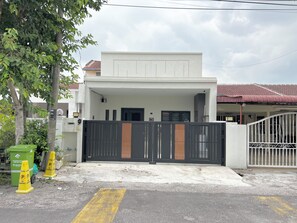 A gated residential property with a covered entrance and a visible garage door.