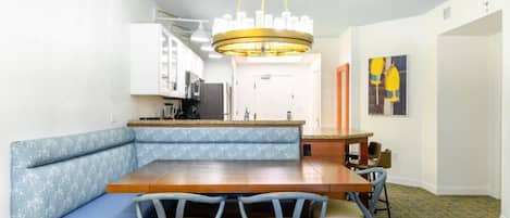 A dining area with a wooden table and blue cushioned bench seating.