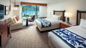 A hotel room with a bed, a sofa, a desk, a chair, a table, and a view of the outdoors. - Kauai | Kauai Ocean Escape | Pool & Beach | 2BR (Lihue)