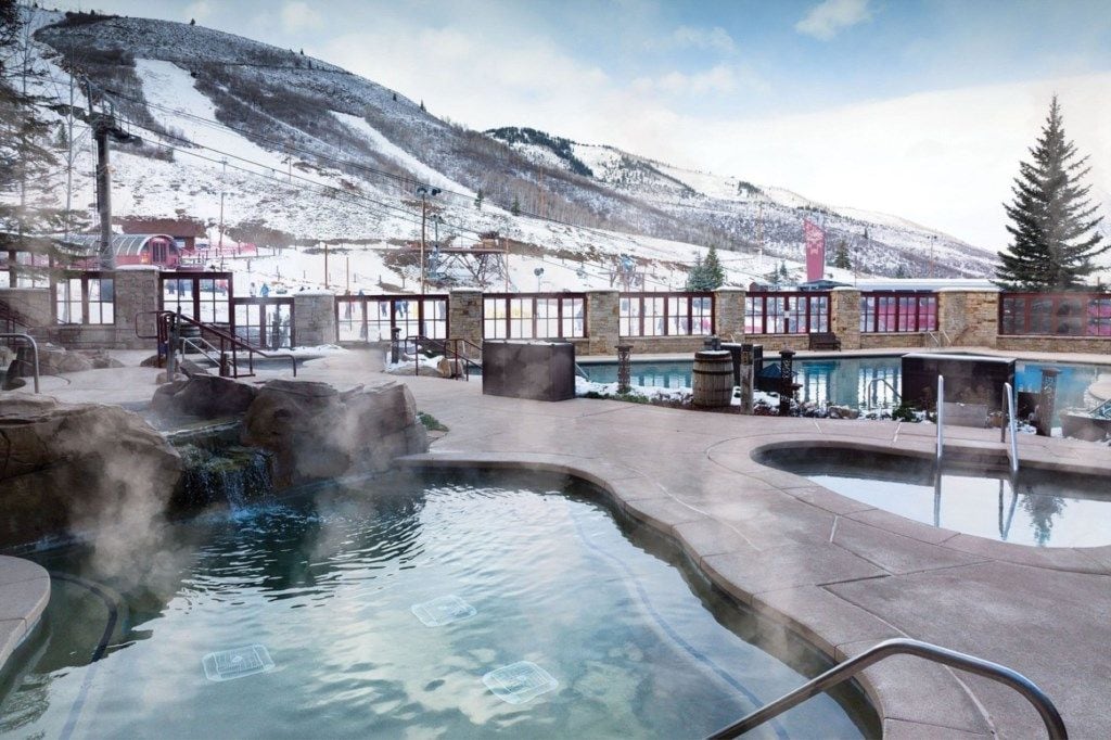 Een wellnessruimte met whirlpools en een berg op de achtergrond.