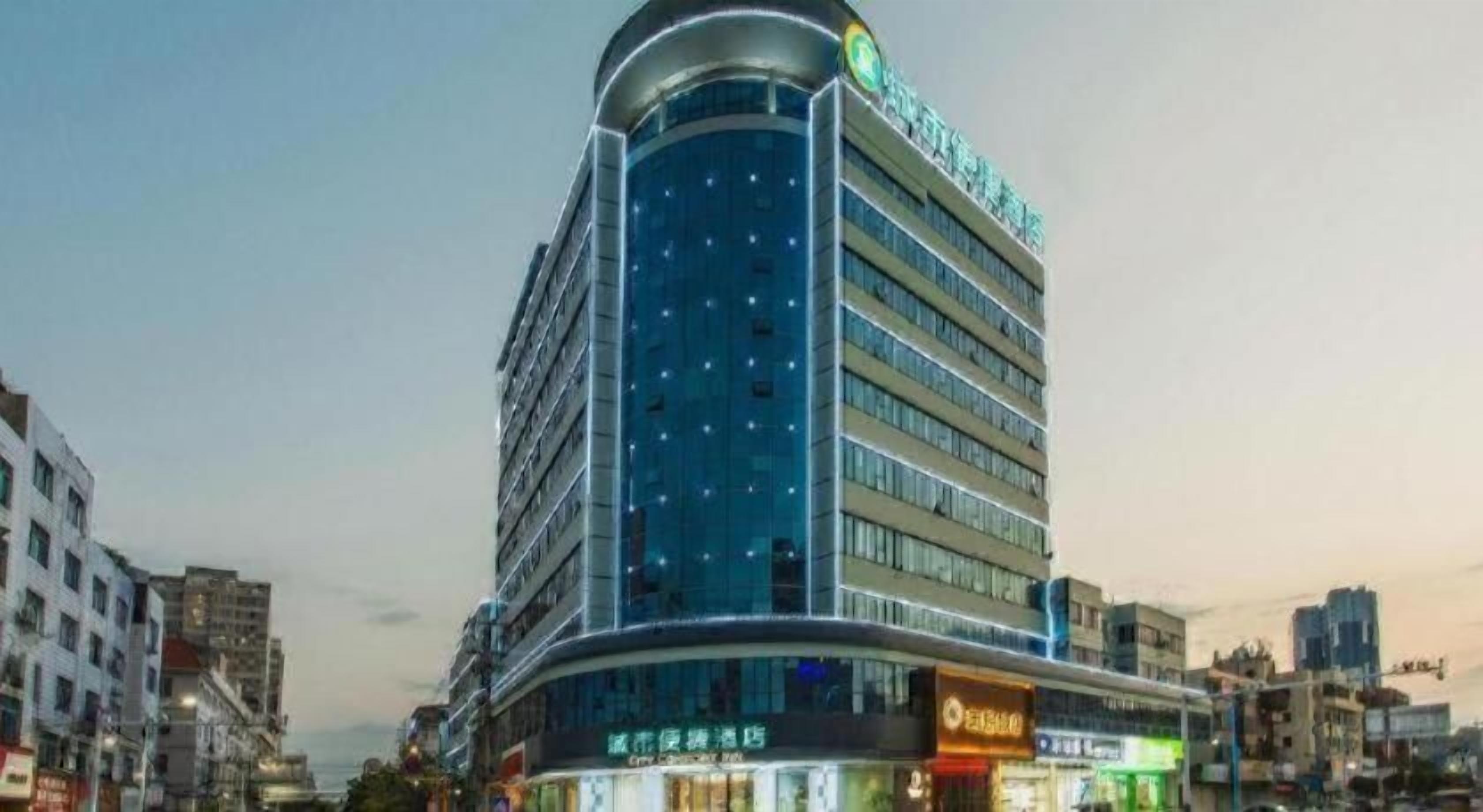 Un hotel de varios pisos con fachada curva, ventanas amplias y señalización llamativa.
