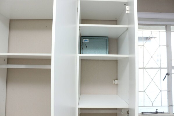 A room with white walls and a window with a grid pattern. There is a blue cabinet with a sign on it. - Charming Self-Catering Apartment in Brackendowns, Alberton (Alberton)