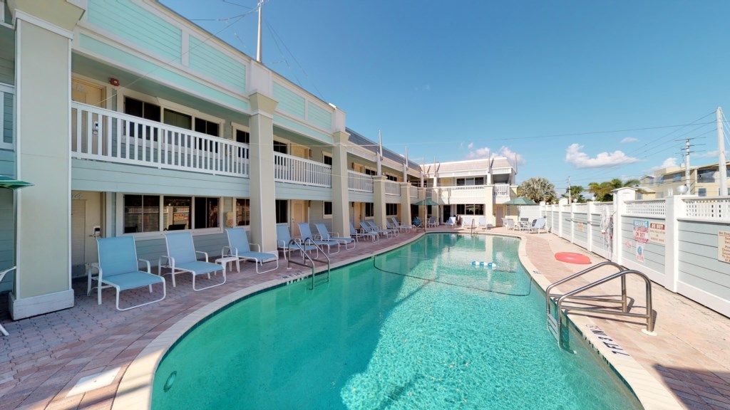 Un hôtel doté d’une piscine, de plusieurs balcons et de chaises longues.