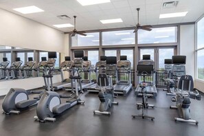 Ein Fitnessstudio mit Laufbändern, Crosstrainern und Krafttrainingsgeräten.