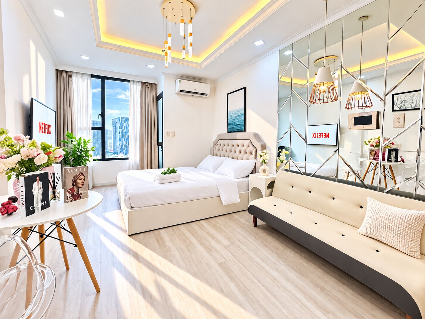 A modern hotel room with a bed, sofa, and a large window with a city view.